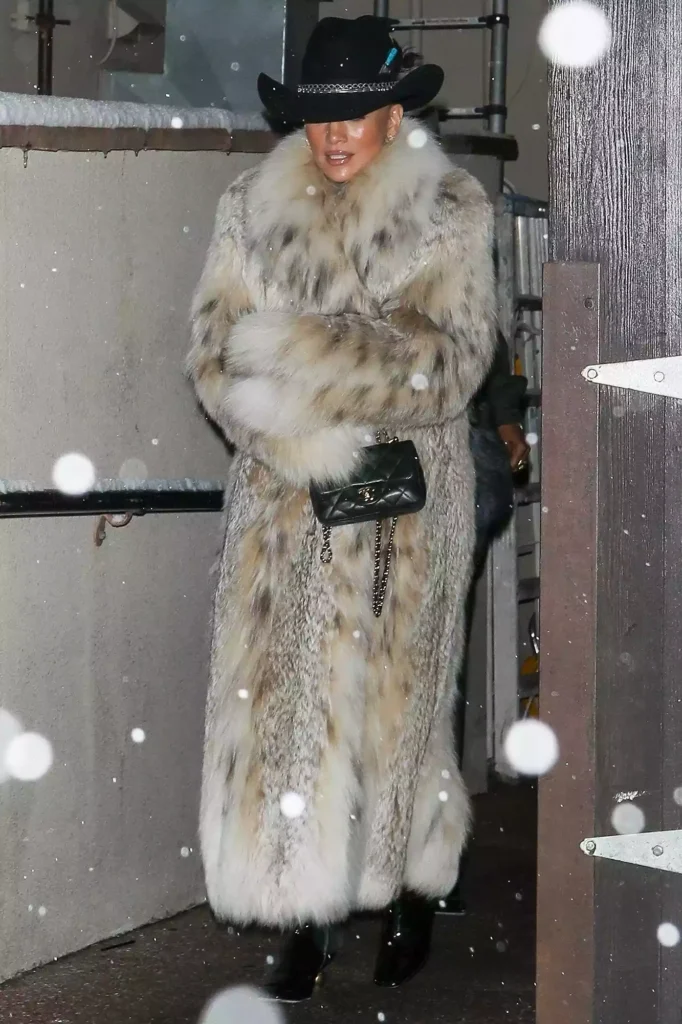 Jennifer Lopez wears a full-length fur coat and black cowboy hat